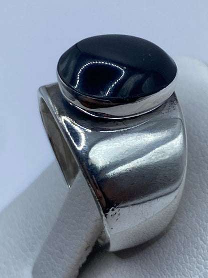 Anillo de ónix negro en la mano mostrando el acabado brillante