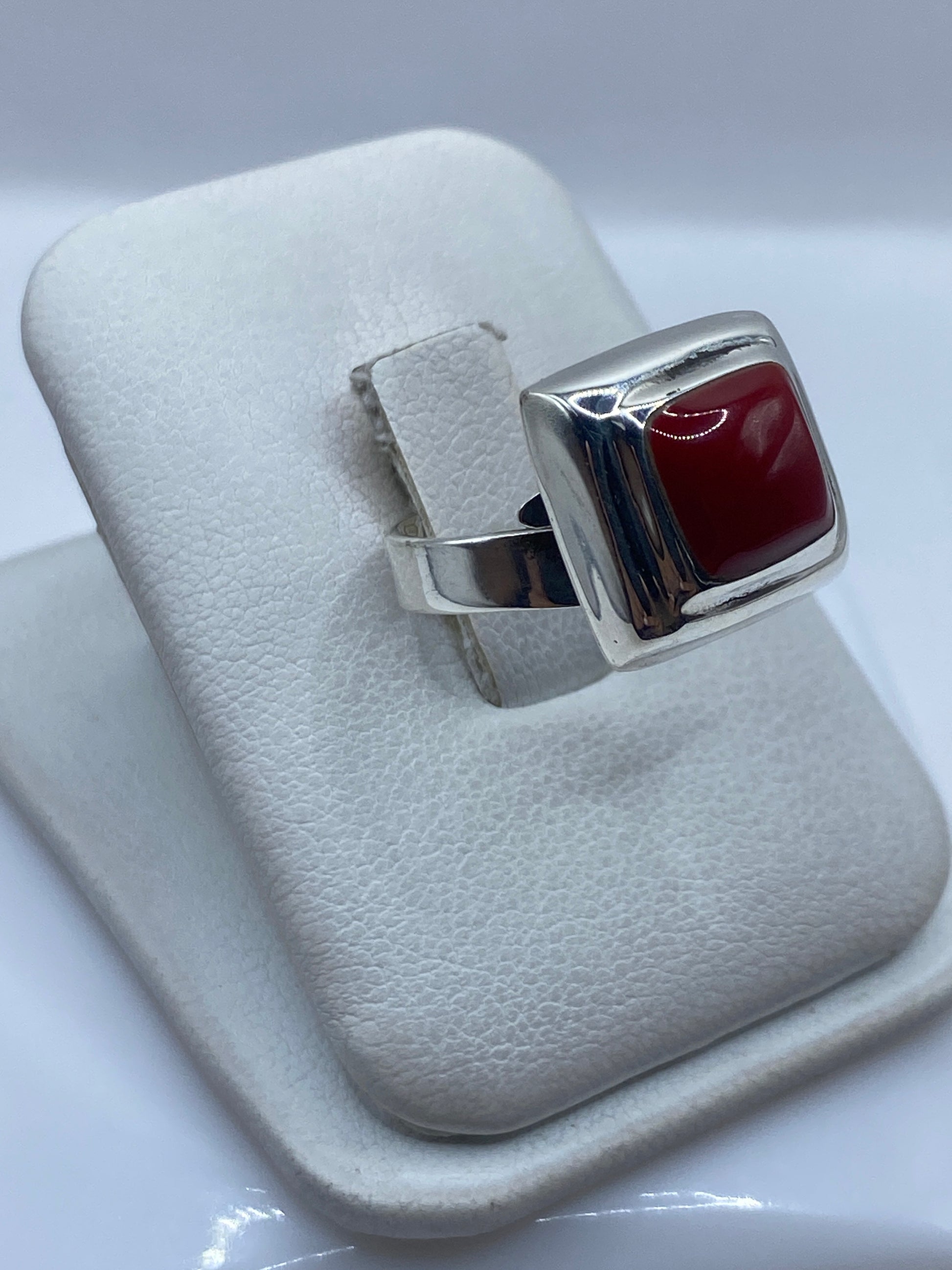 Anillo de plata ajustable con piedra roja colocado en el dedo índice de una mujer