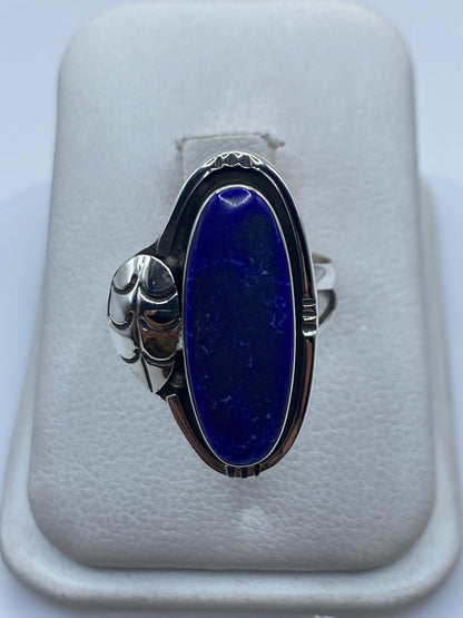 Anillo de plata con piedra azul engastada, visto de frente sobre fondo blanco