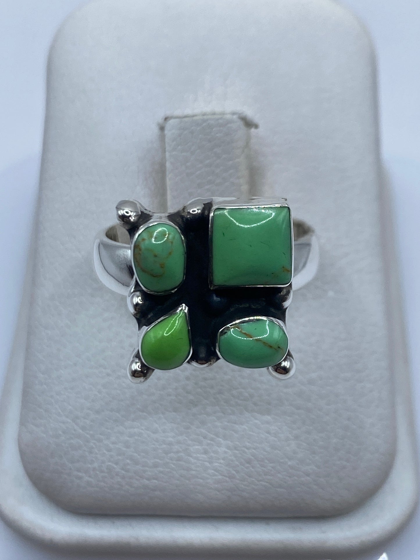 Anillo de plata .925 con cuatro piedras verdes engastadas en diseño geométrico
