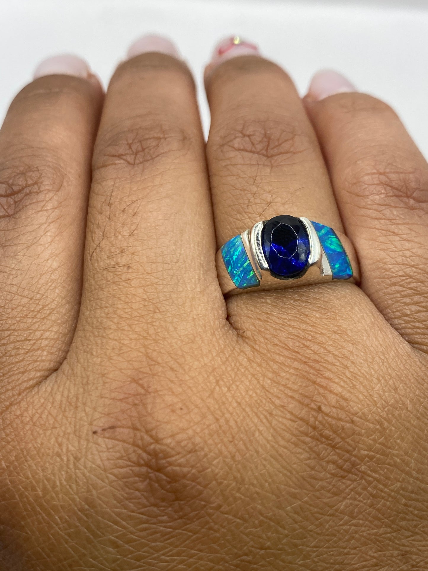 Anillo sobre fondo blanco con la luz reflejada en el fuego del ópalo