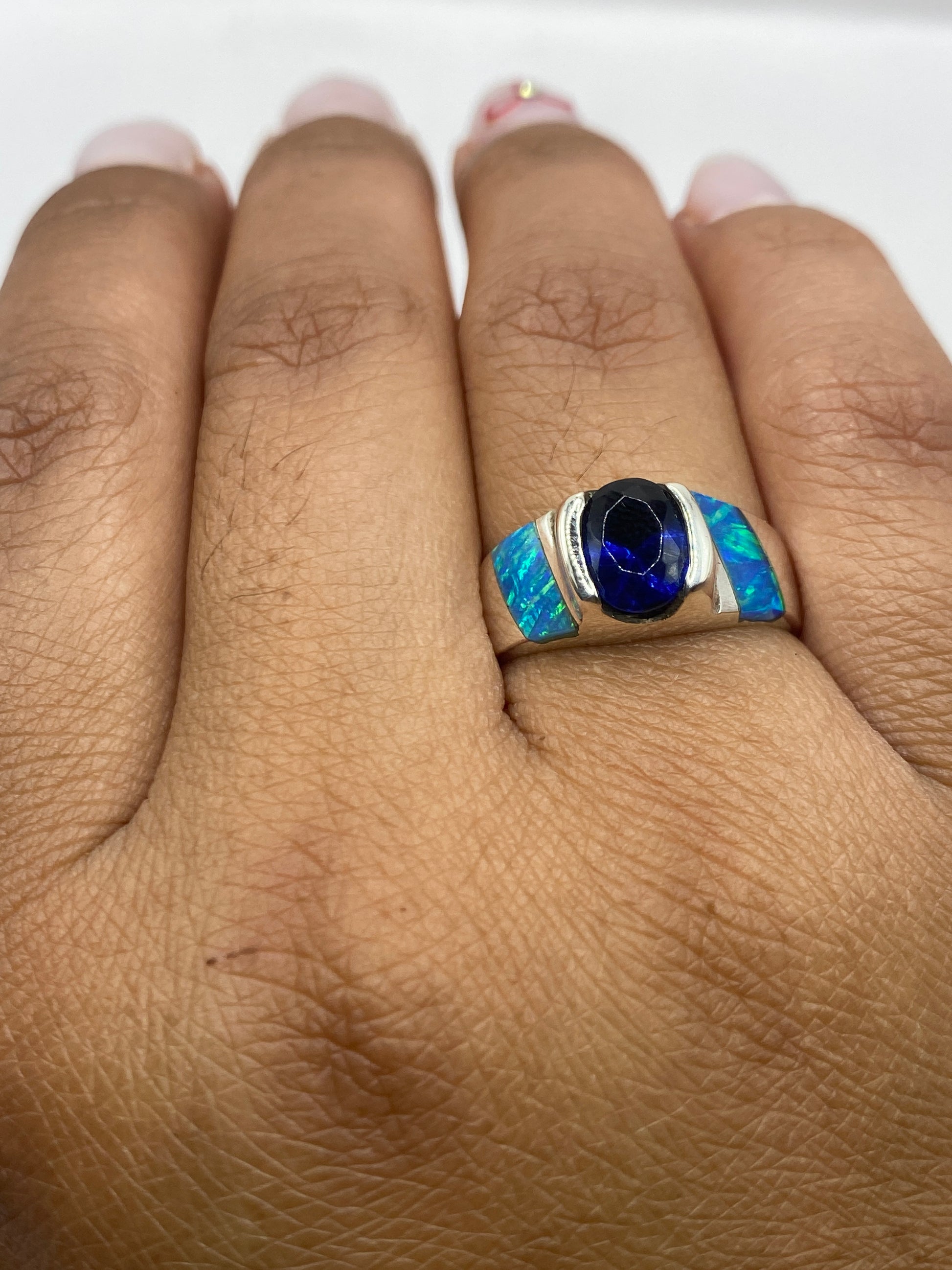Anillo sobre fondo blanco con la luz reflejada en el fuego del ópalo