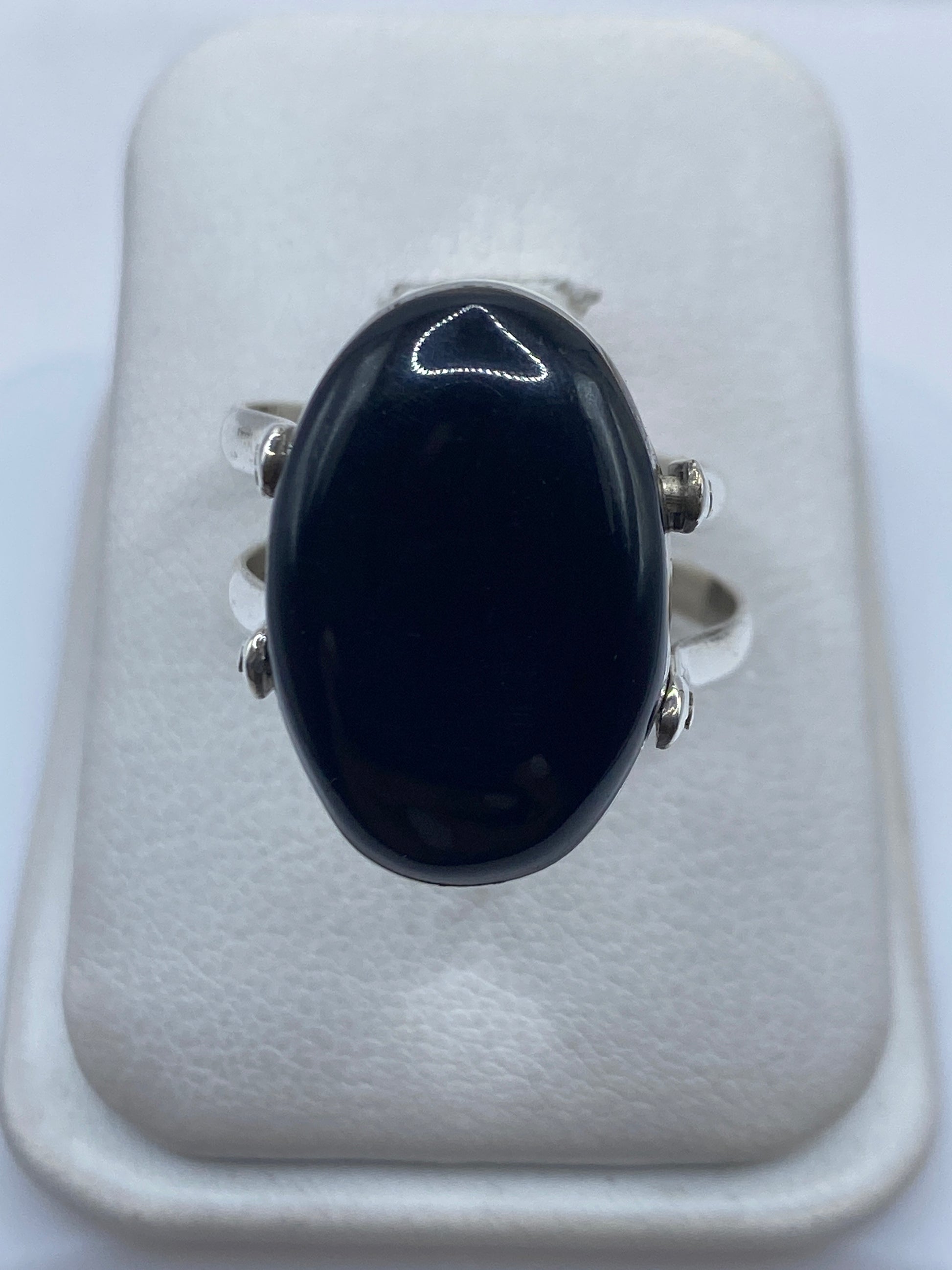 Anillo de plata .925 con ónix negro pulido en la mano de una mujer