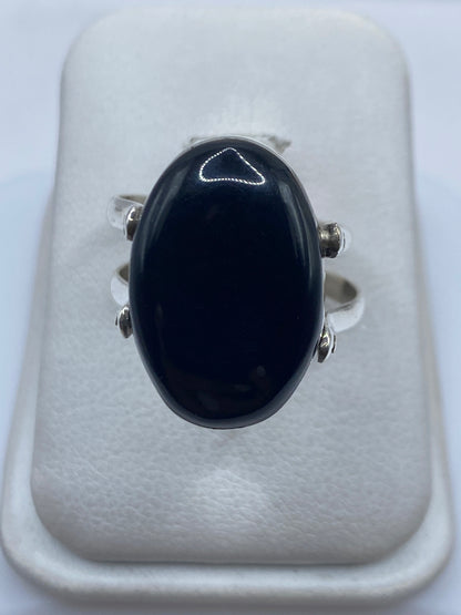 Anillo de plata .925 con ónix negro pulido en la mano de una mujer