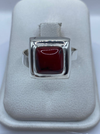 Anillo ajustable de plata .925 con coral rojo engastado a mano, visto desde arriba en estuche blanco