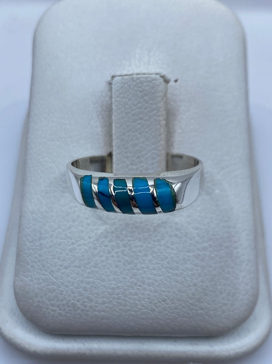 Anillo de plata con cinco incrustaciones de turquesa azul cielo en la mano