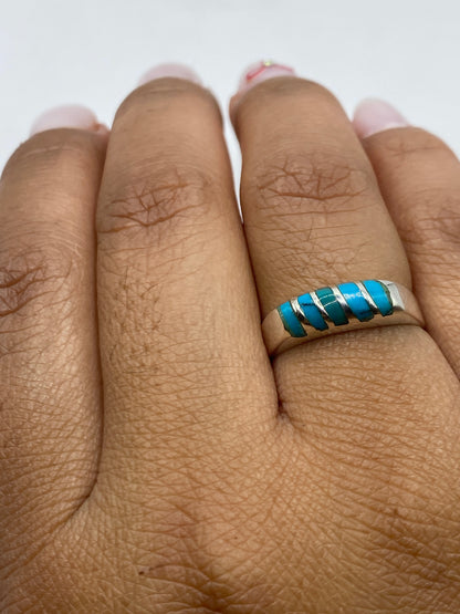 Anillo de turquesa sobre fondo gris con sello de .925 visible