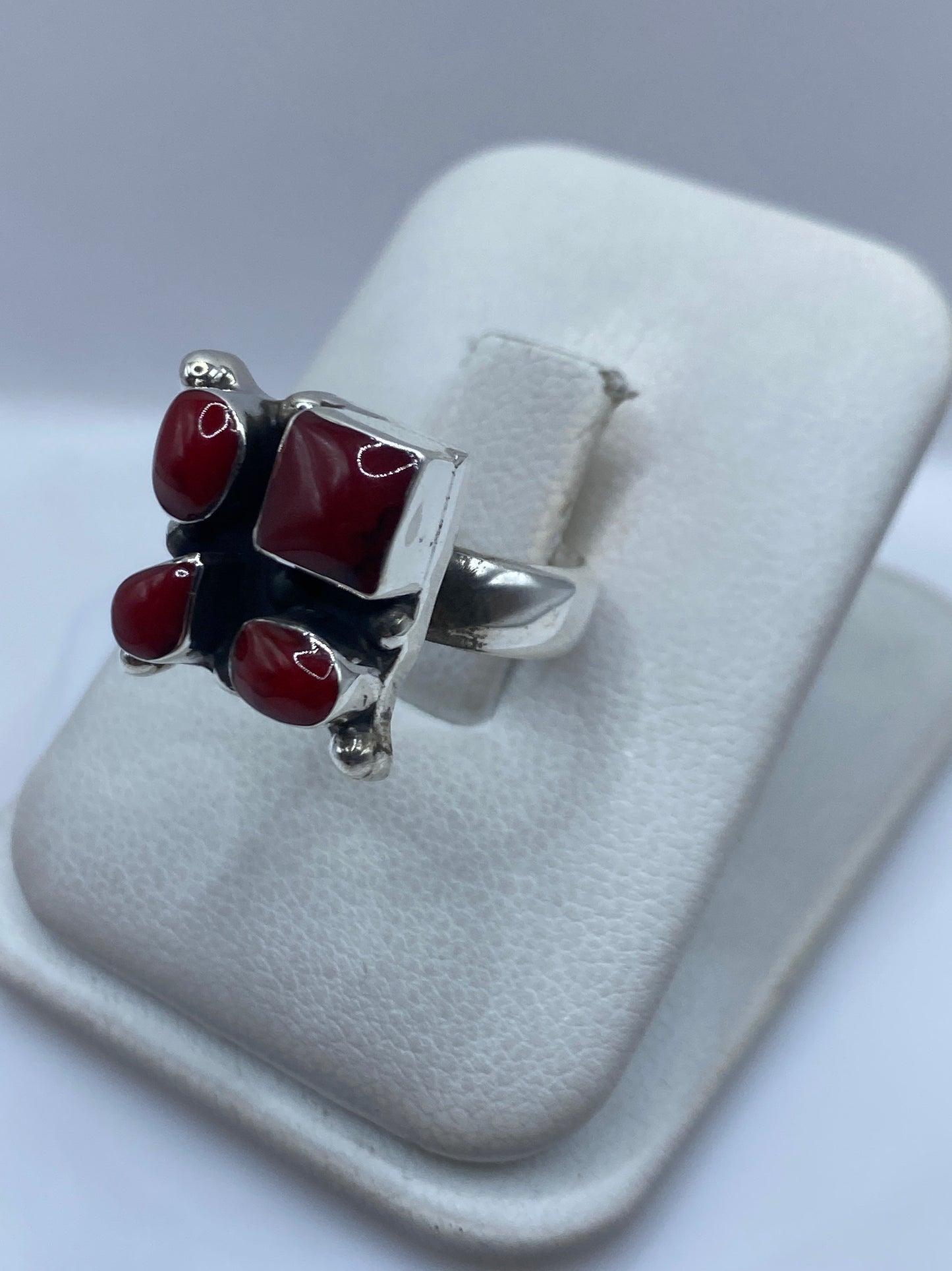 Vista frontal del anillo de coral con plata satinada y pulida de Taxco