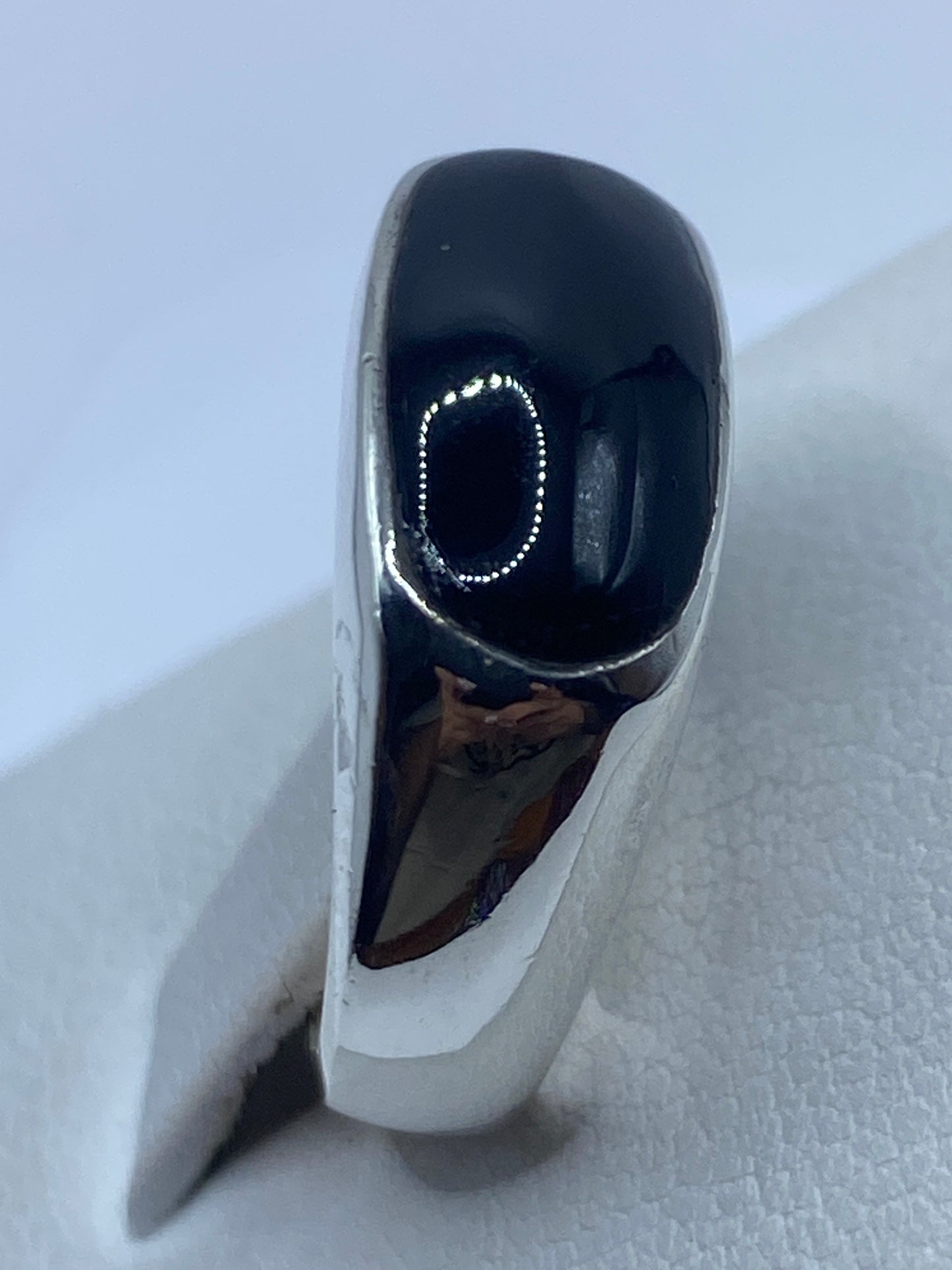 Anillo de ónix en mano mostrando el acabado pulido y reflejo