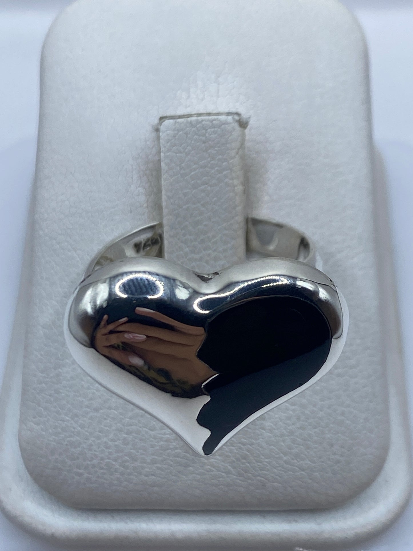 Anillo de plata ajustable con ónix negro en forma de corazón, visto de frente sobre estuche blanco