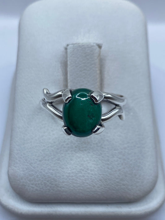 Anillo de plata engastado a mano con malaquita verde en display de joyería