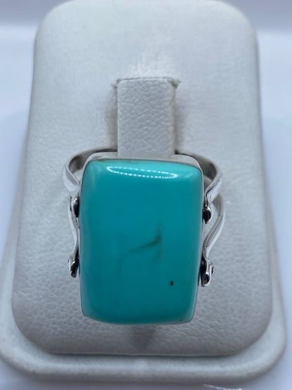 Anillo de plata con turquesa azul cielo en joyero de la mano de una mujer
