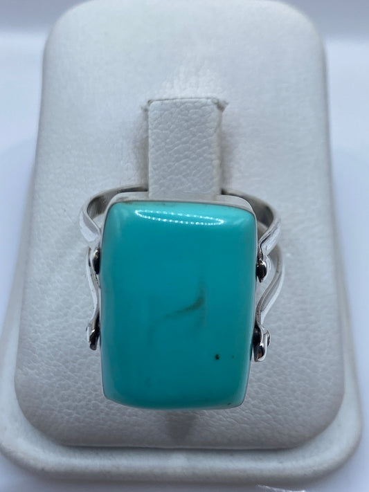 Anillo de plata con turquesa azul cielo en joyero de la mano de una mujer