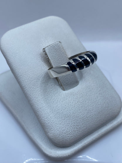 Anillo de ónix y plata en la mano, mostrando el engaste de la piedra