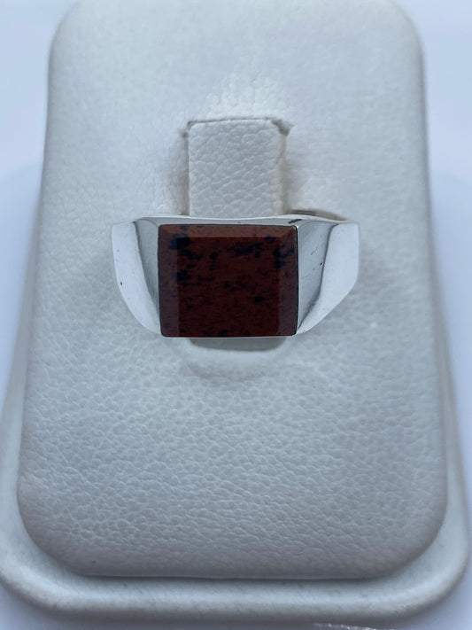 Anillo de plata .925 con piedra café engastada en mano, sobre fondo blanco