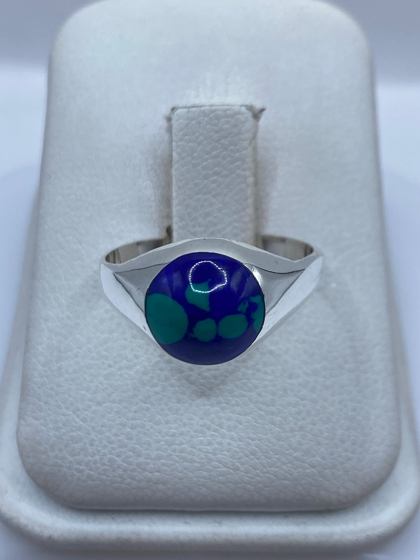Anillo de plata .925 con piedra azul engastada, visto desde arriba en estuche blanco