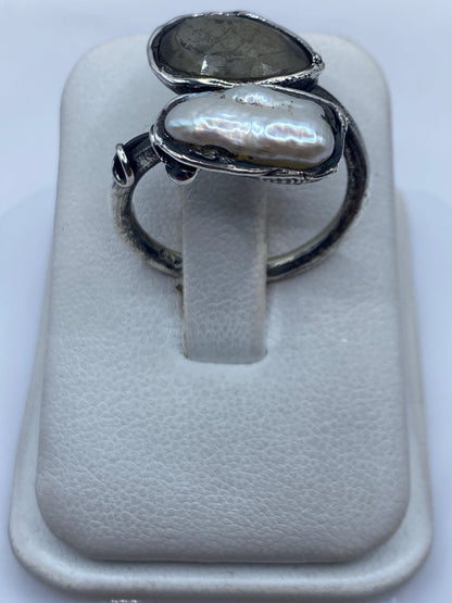 Anillo de plata ajustable con perla blanca nacarada, vista frontal sobre fondo blanco