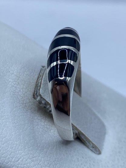 Anillo de ónix y plata en dedo, mostrando el diseño minimalista
