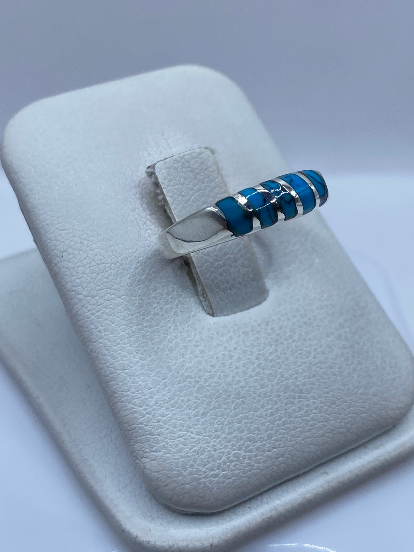 Vista lateral del anillo mostrando los cinco segmentos de turquesa alternados con plata pulida