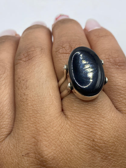 Anillo de coral en mano, luciendo el tono rojo profundo bajo luz natural