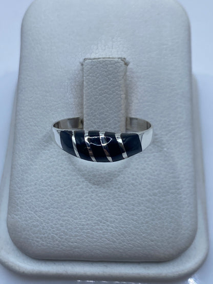 Anillo de plata .925 con ónix negro engastado en la mano de una persona
