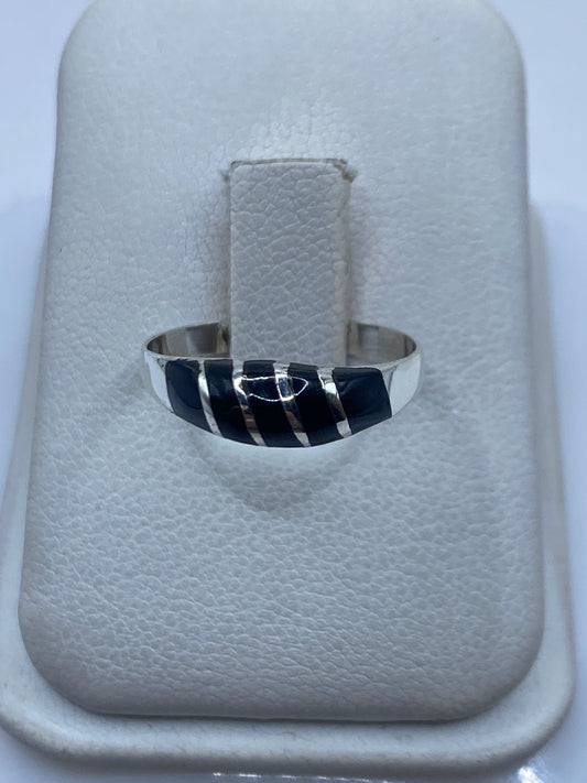 Anillo de plata .925 con ónix negro engastado en la mano de una persona