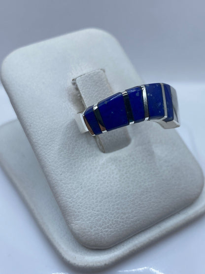 Anillo de lapislázuli y plata en la mano de una mujer, detalle de la incrustación