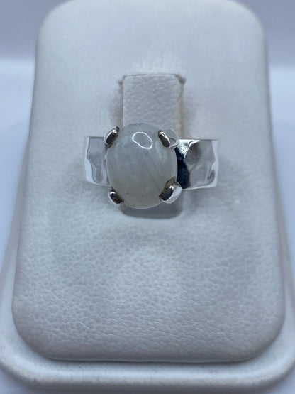 Anillo de plata .925 con piedra blanca engastada, visto de frente sobre estuche blanco