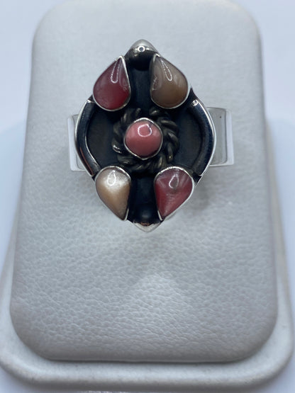 Anillo ajustable de plata con piedra rosa incrustada visto desde arriba en estuche blanco