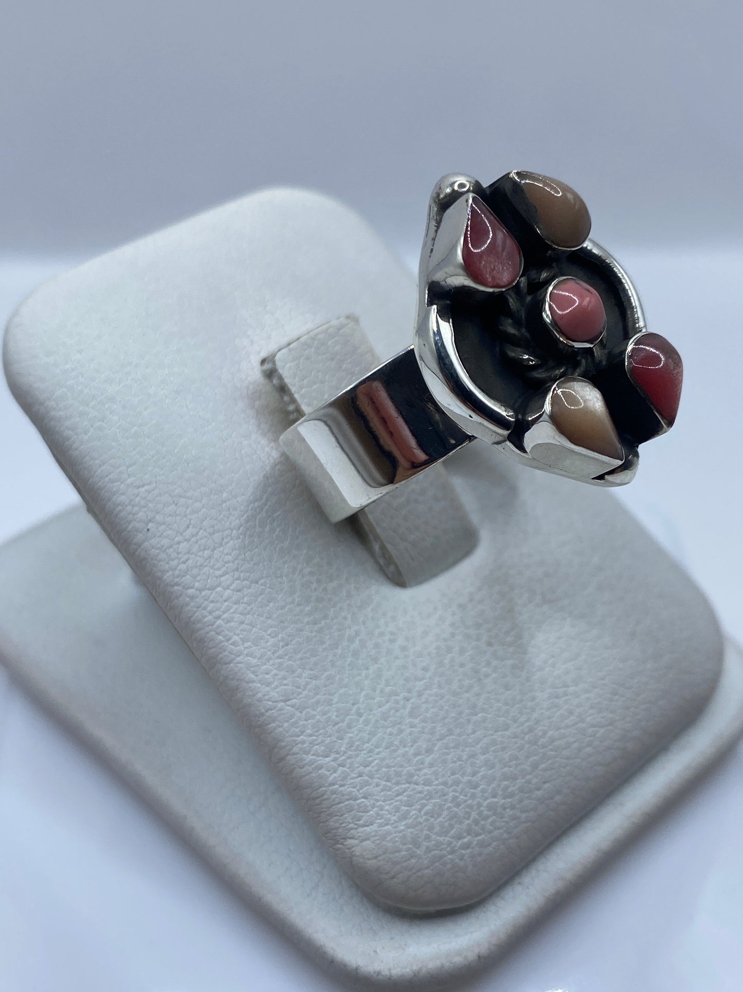Anillo de plata ajustable en la mano mostrando la incrustación de piedra rosa