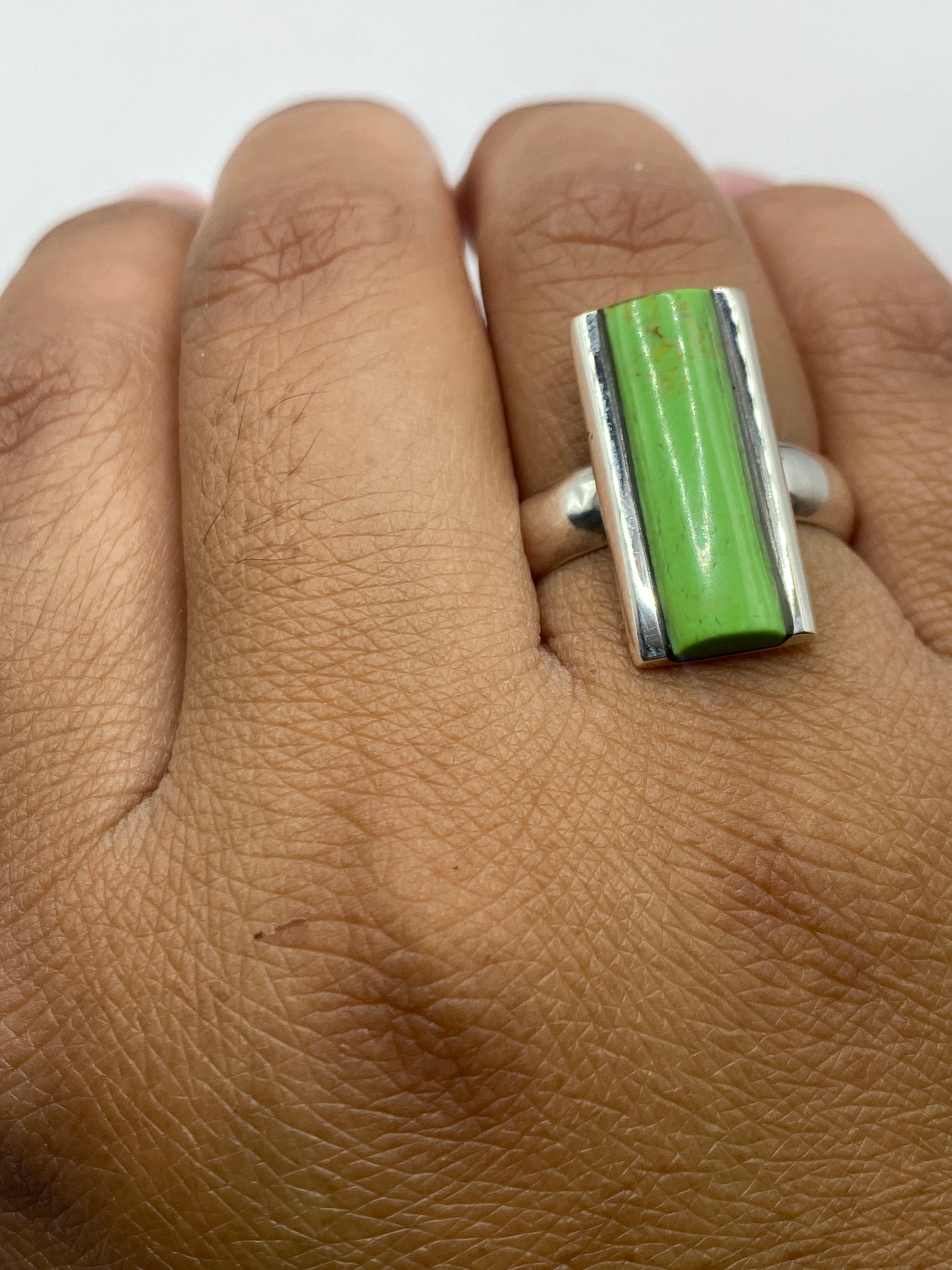 Anillo sobre fondo neutro revelando el pulido brillante de la plata
