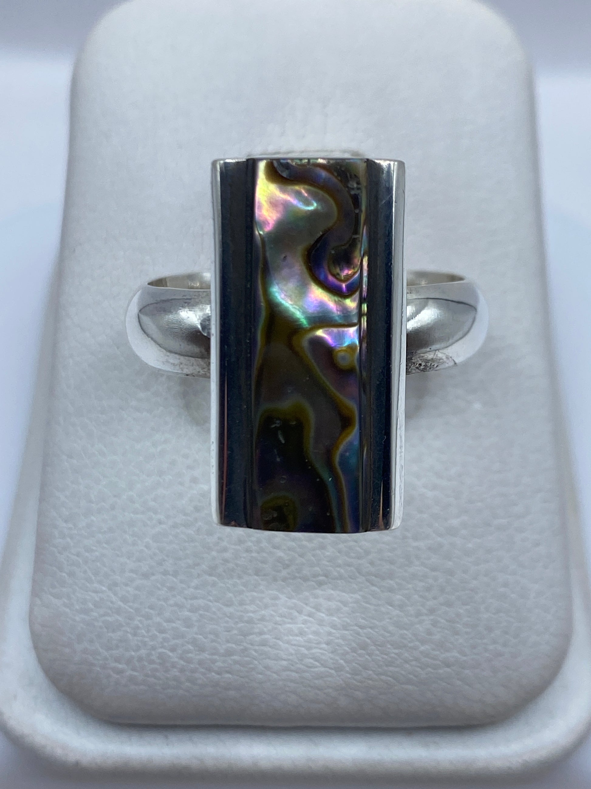 Anillo de plata con piedra natural engastada a mano, visto de frente en presentador blanco