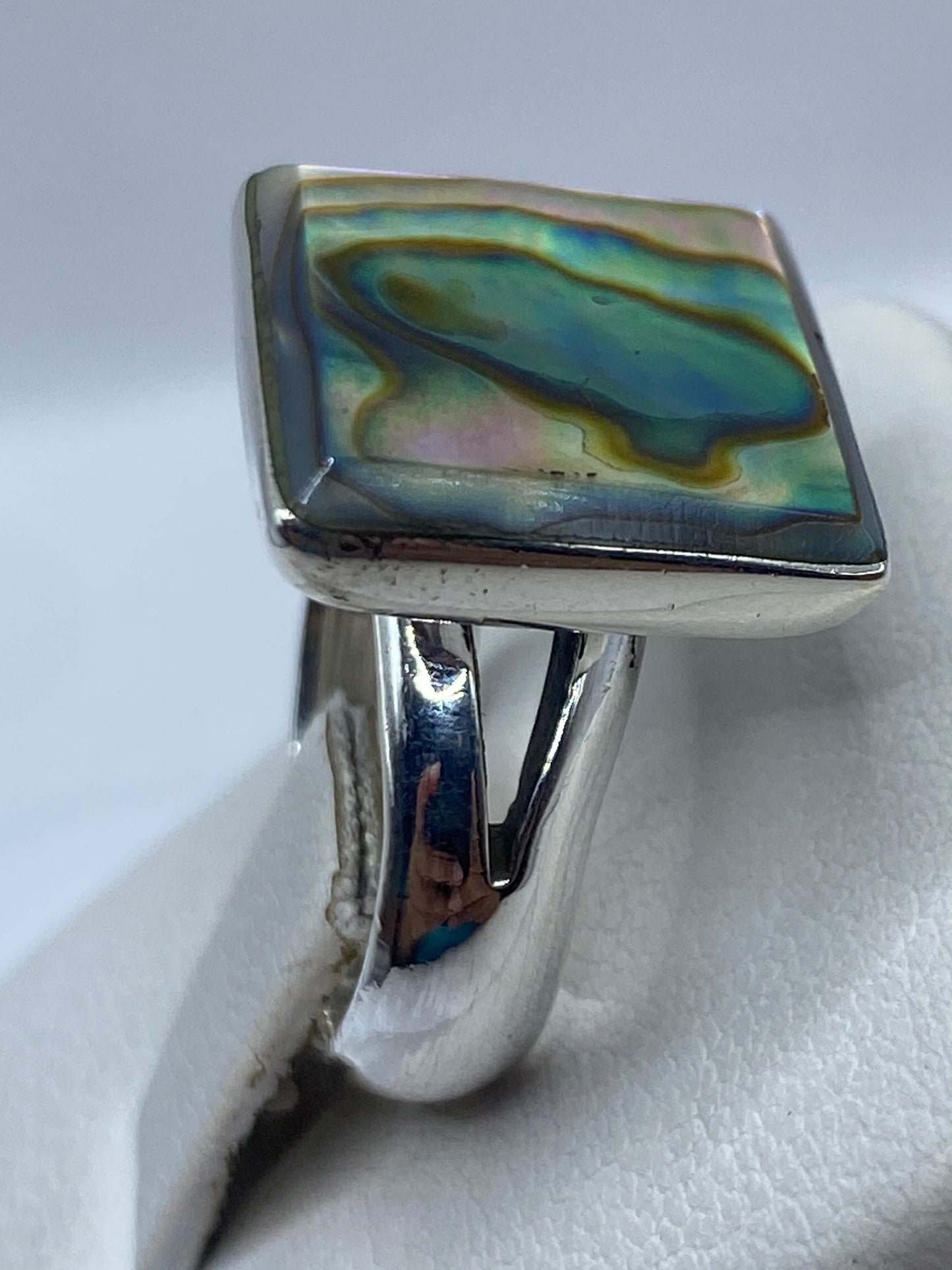 Anillo en la mano de una mujer mostrando el acabado espejo y la piedra
