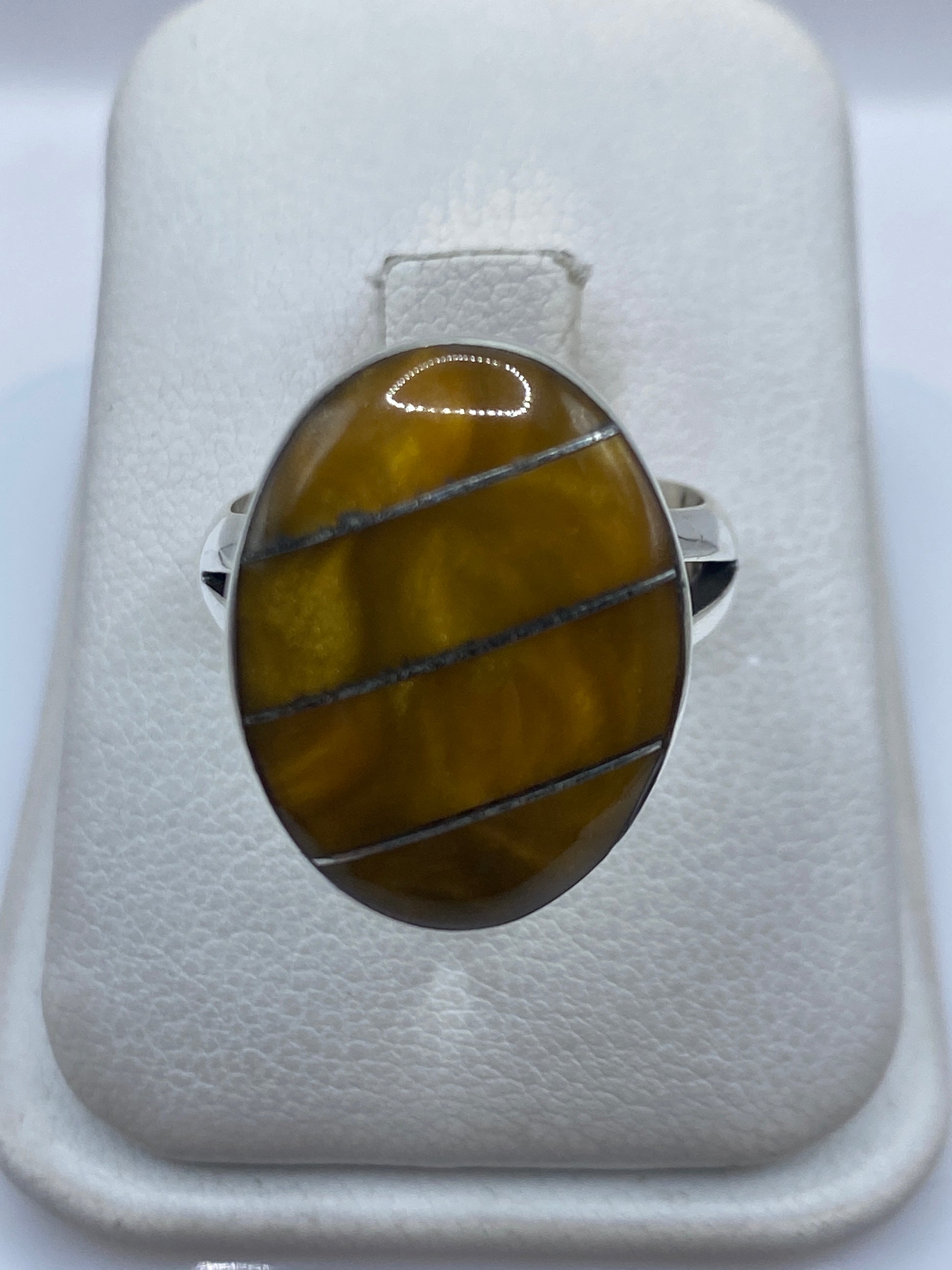 Anillo de plata .925 con piedra café, visto de frente en caja blanca