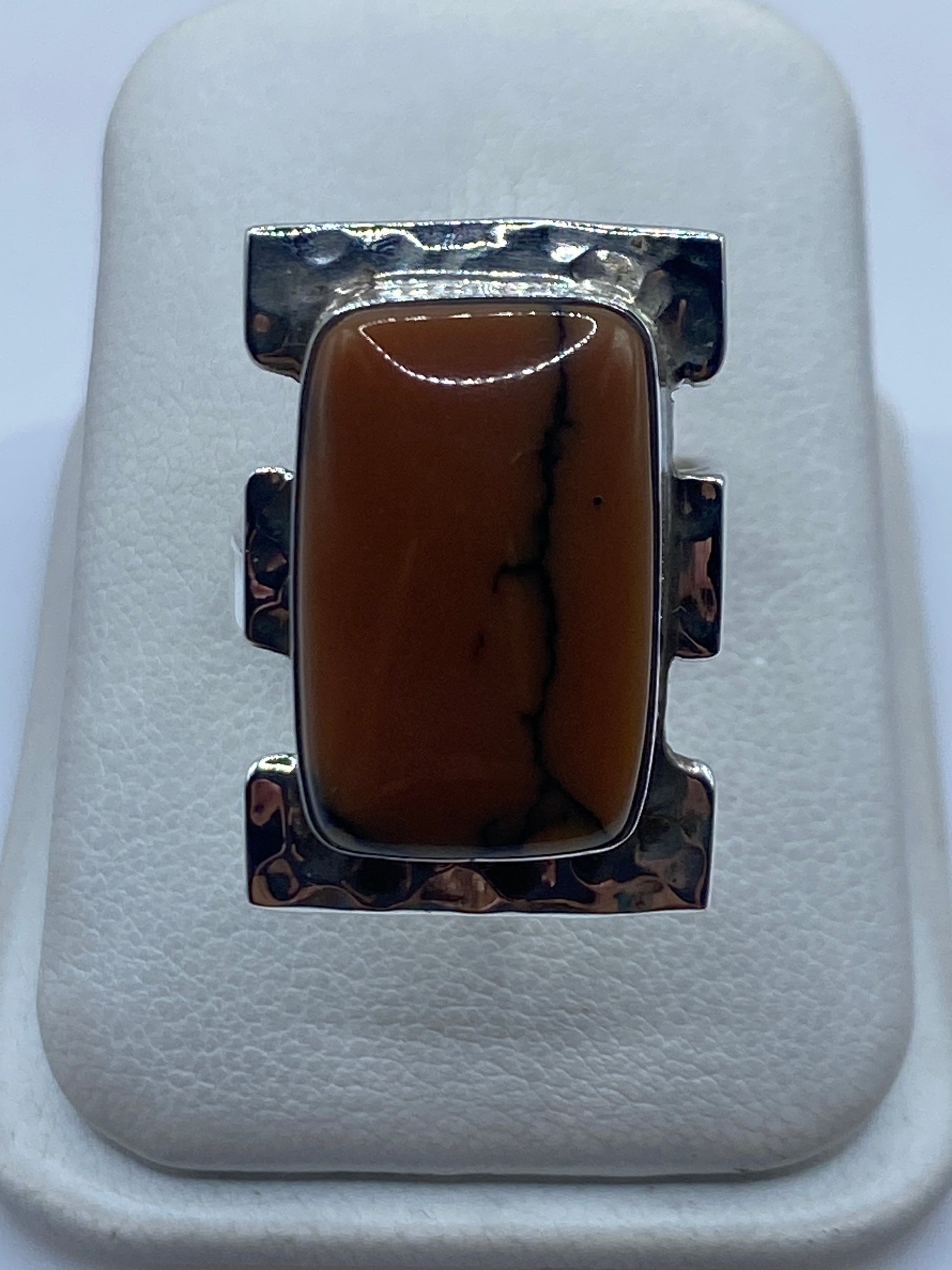 Anillo ajustable de plata .925 con piedra café engastada a mano en dedo de mujer