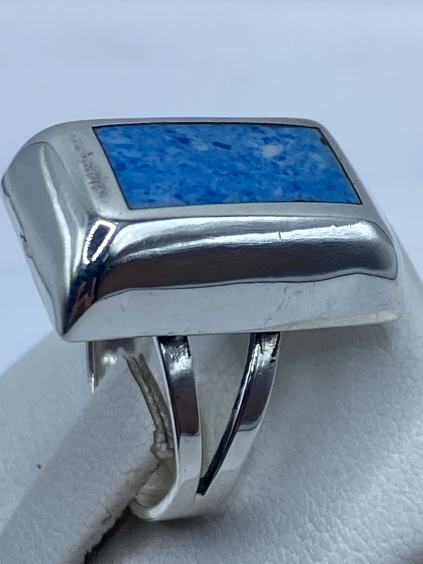 Detalle lateral del anillo minimalista con piedra azul intenso