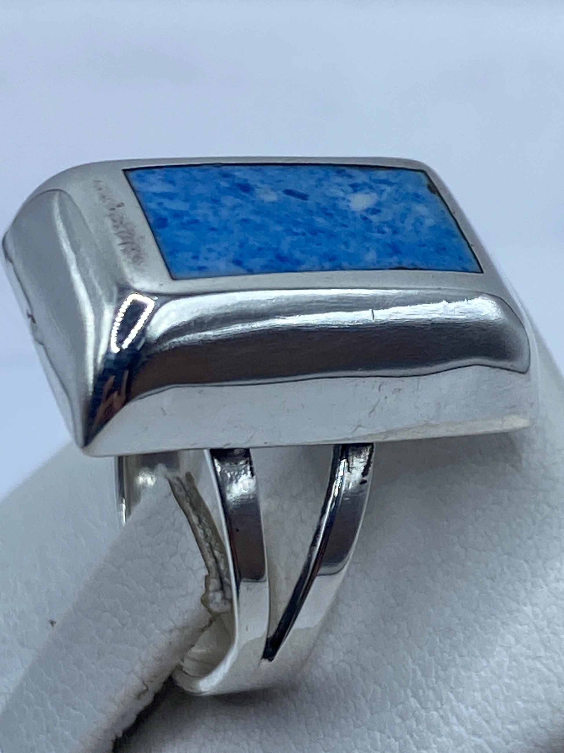 Detalle lateral del anillo minimalista con piedra azul intenso