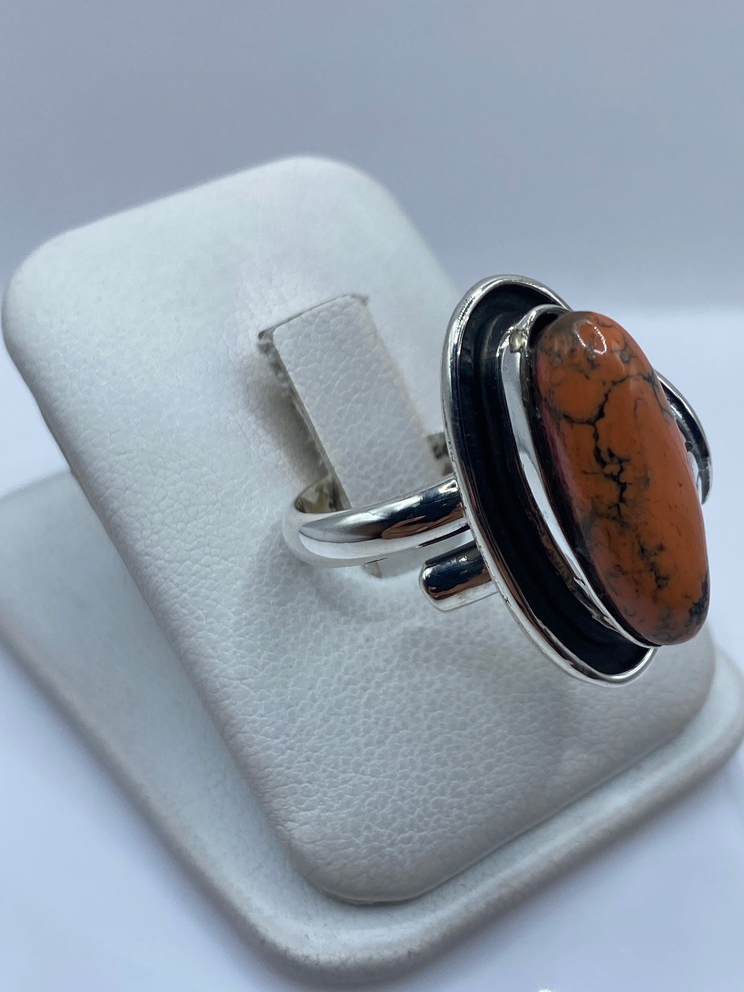 Detalle del engaste a mano: piedra rodeada por plata pulida y óxido negro