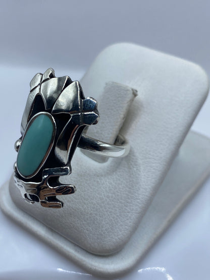 Detalle frontal del anillo prehispánico mostrando el engaste de turquesa y motivos tallados