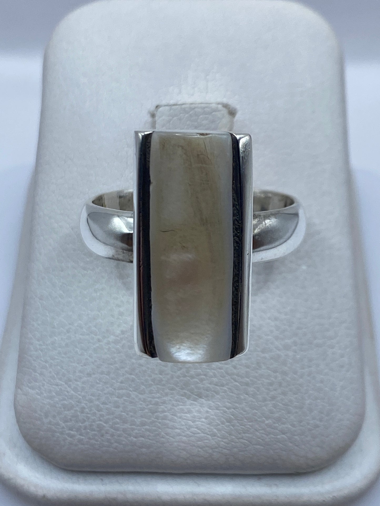 Anillo de plata con perla blanco cremoso engastada, visto sobre fondo neutro