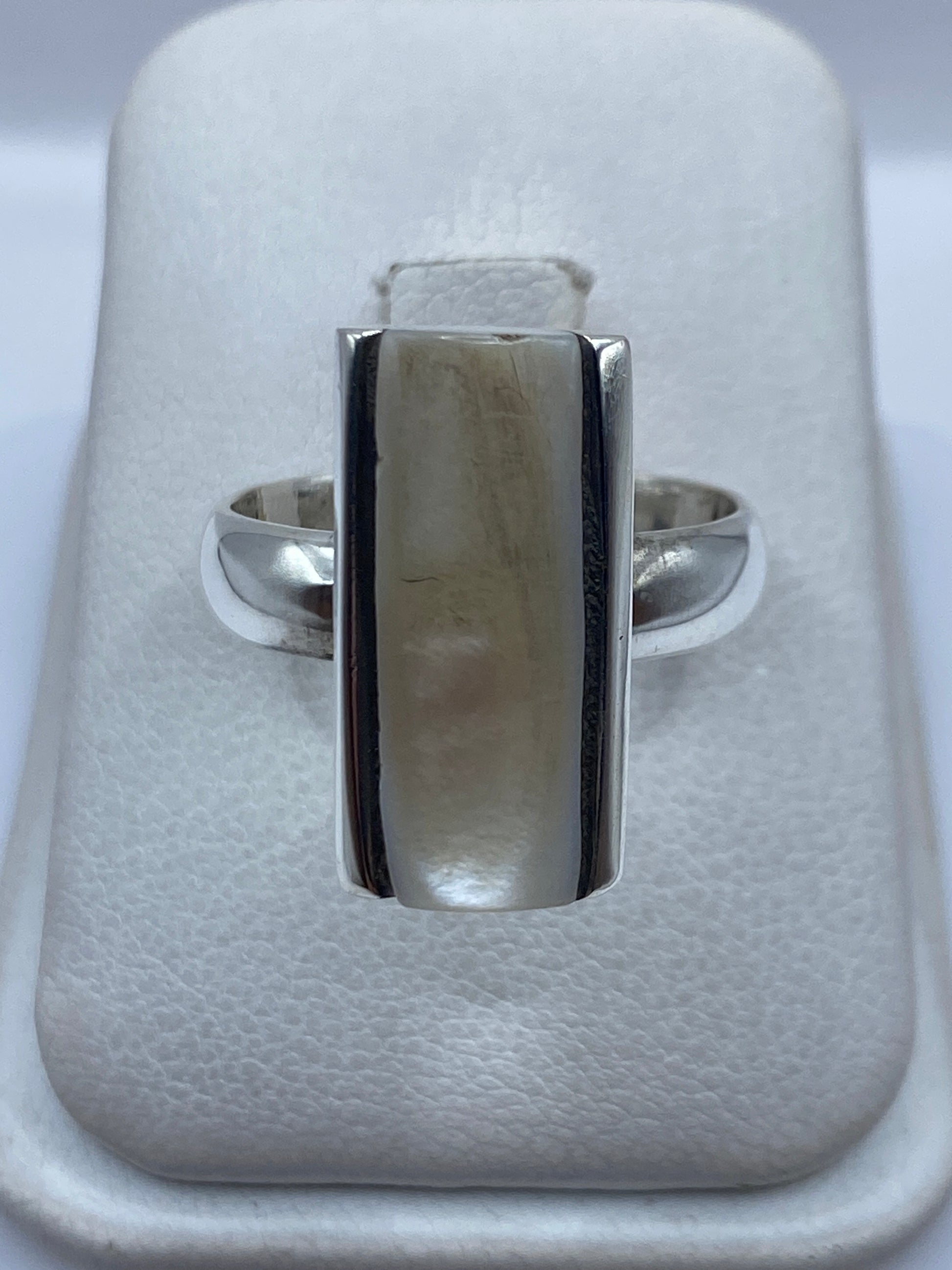 Anillo de plata con perla blanco cremoso engastada, visto sobre fondo neutro