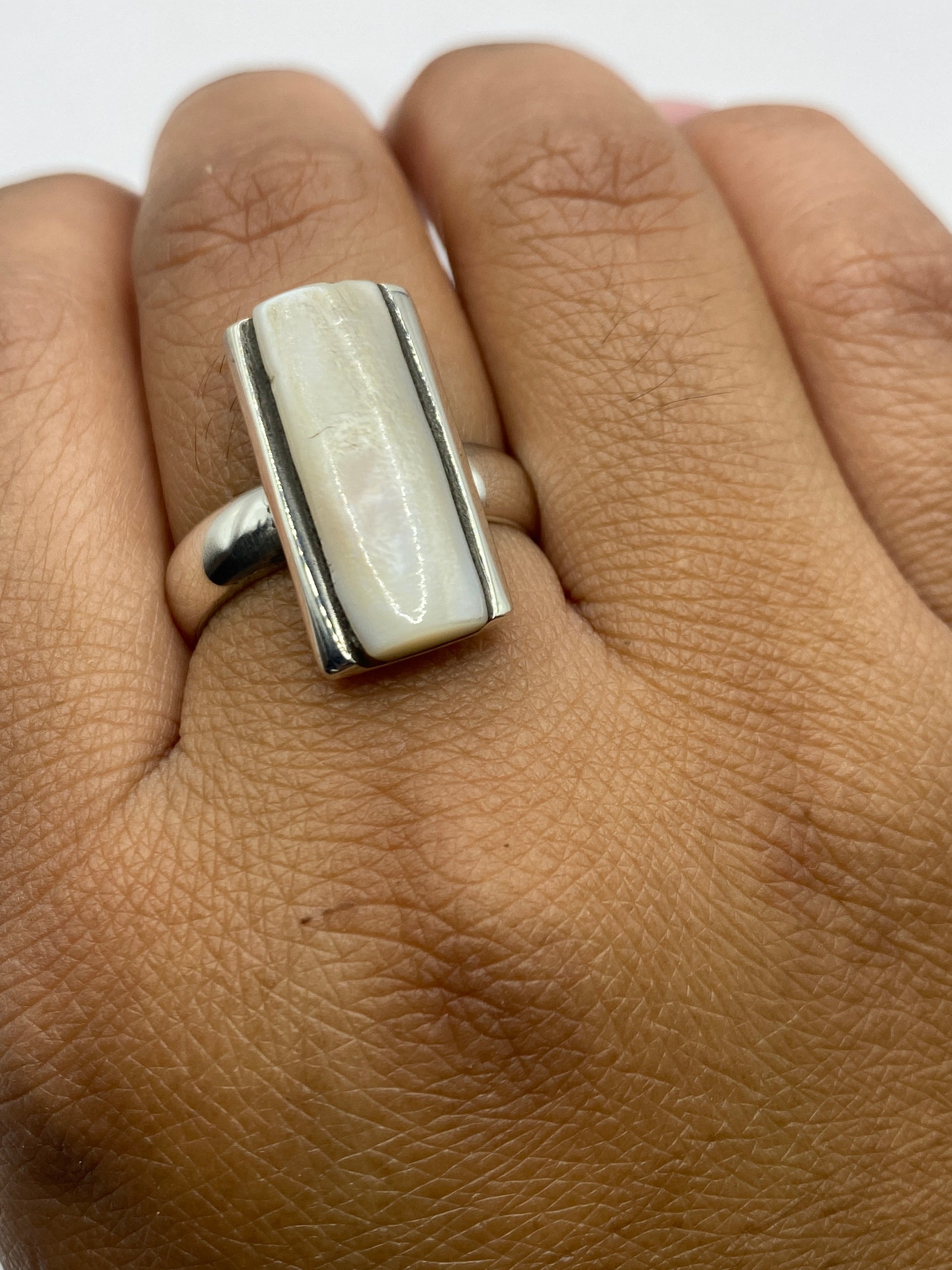 Anillo con perla puesto en dedo, mostrando el brillo y la elegancia de la pieza
