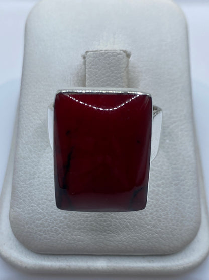Anillo de plata .925 con coral rojo engastado, visto de frente en estuche blanco