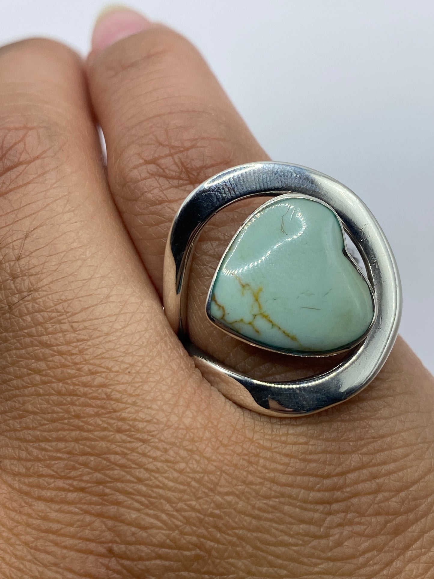 Anillo en mano mostrando el tono azul cielo de la turquesa