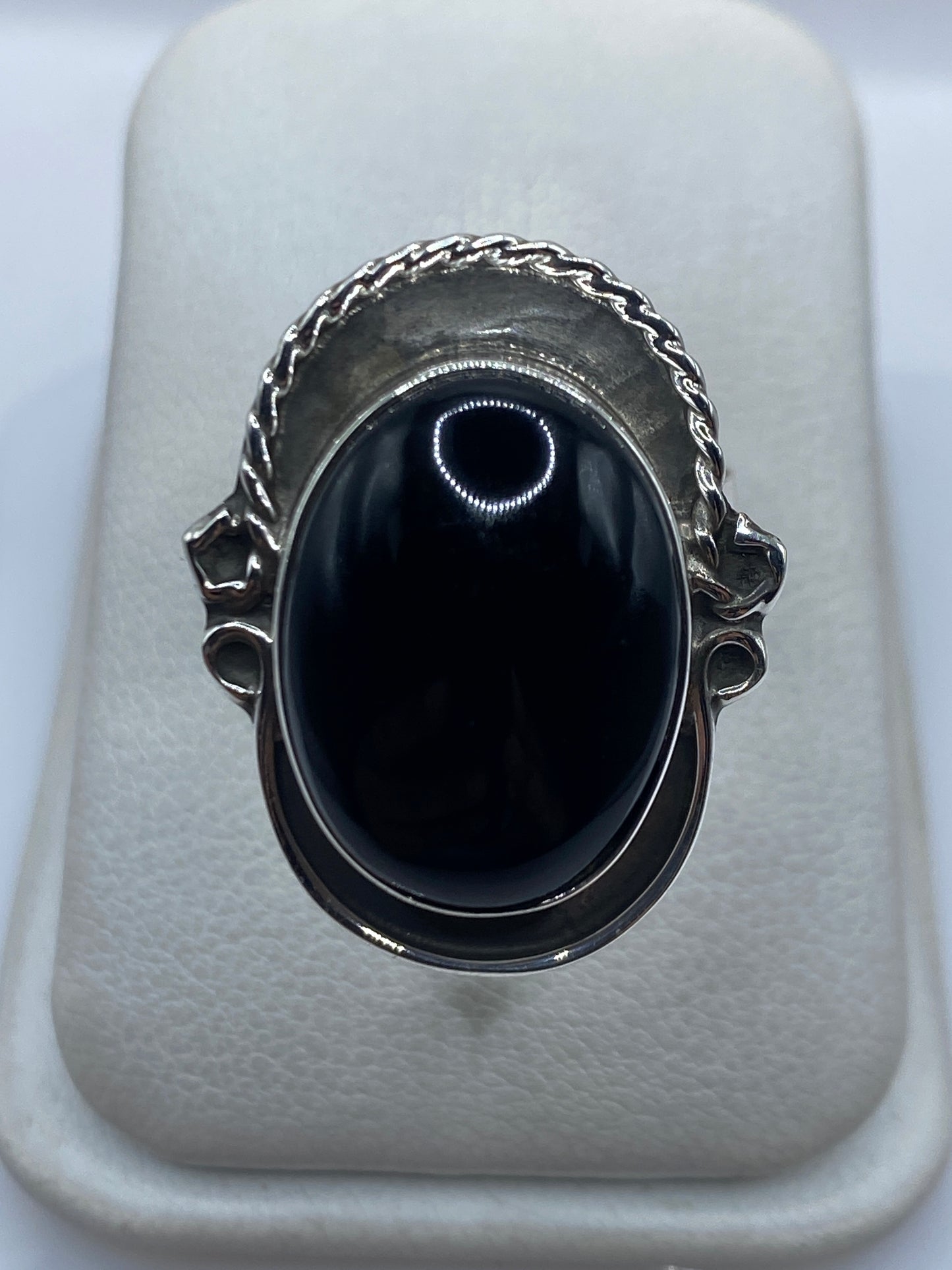 Anillo de plata ajustable con ónix negro brillante, vista frontal sobre fondo blanco