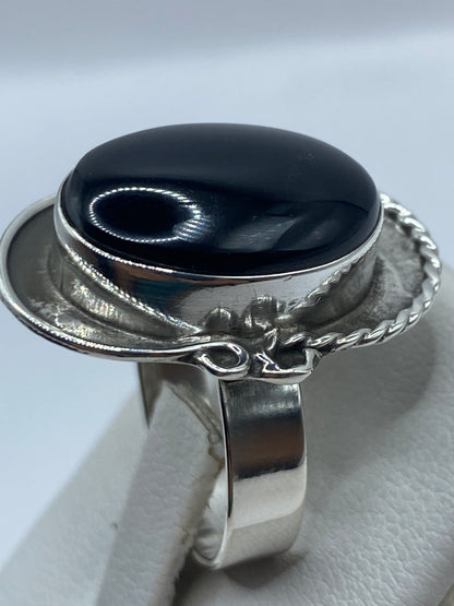 Anillo ajustable de ónix puesto en dedo, mostrando cómo se adapta