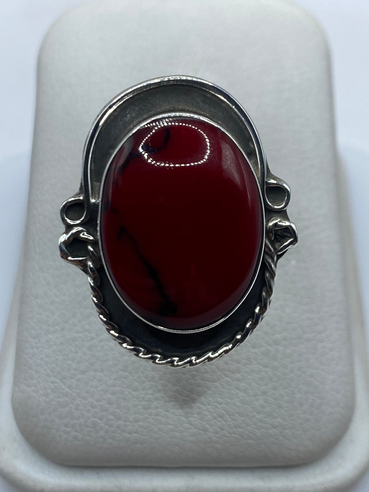 Anillo de plata ajustable con coral rojo vivo en mano de mujer