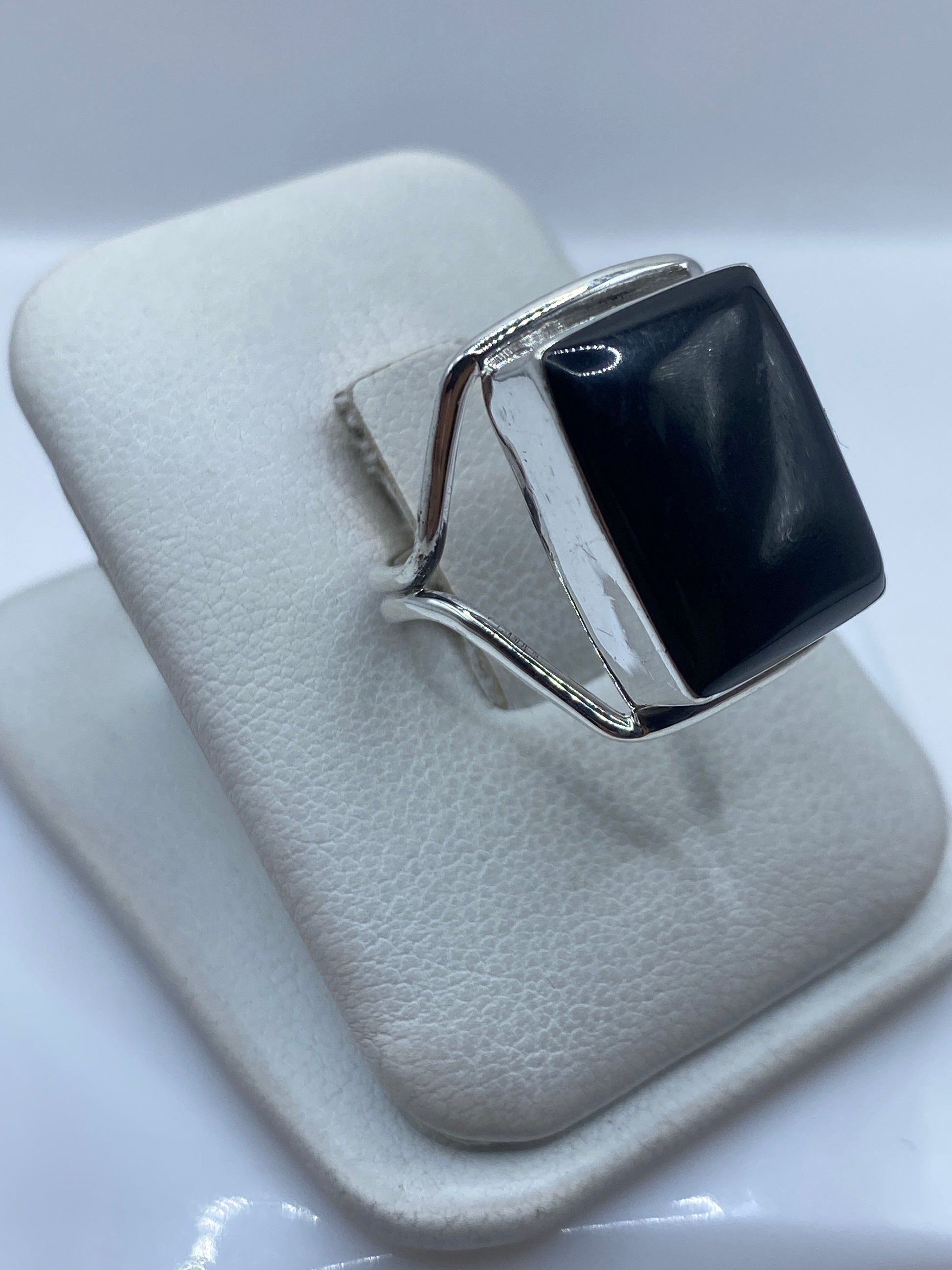 Anillo de plata .925 con ónix negro puesto en dedo, mostrando el engaste pulido