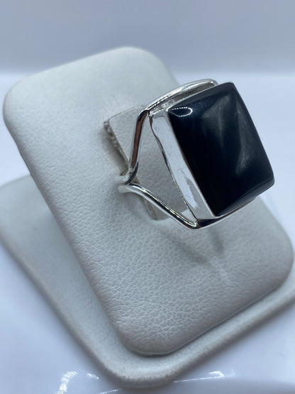 Anillo de plata .925 con ónix negro puesto en dedo, mostrando el engaste pulido
