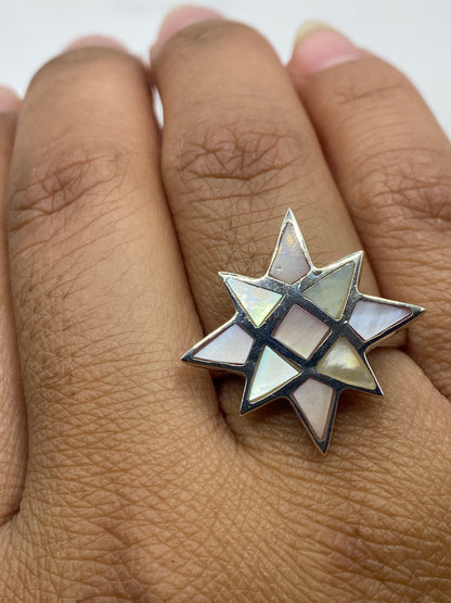 Anillo en la mano mostrando el tamaño y el brillo de las piedras multicolor bajo la luz
